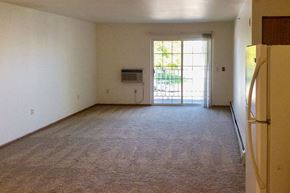 Chilton apartment for rent - an empty living room with a refrigerator and a door