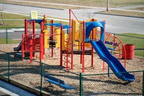 Chanute apartment for rent - A playground with a blue slide and red and yellow play structures.