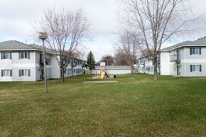 Albert Lea apartment for rent - a group of houses in a yard with a playground