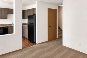 Northfield apartment for rent - A black refrigerator is in a kitchen with brown cabinets.
