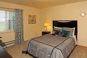 Fond Du Lac apartment for rent - A bedroom with a large bed and a window with curtains.