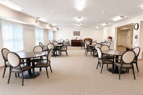 Creston apartment for rent - A room with tables and chairs and a clock on the wall.