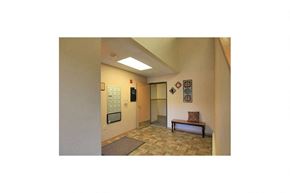 Yankton apartment for rent - A hallway with a bench and a door at the end.