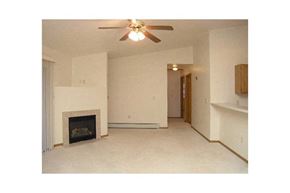 Green Bay apartment for rent - A living room with a fireplace and a ceiling fan.