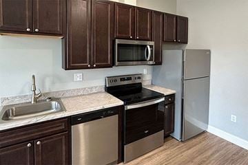 Charles City apartment for rent - a kitchen with stainless steel appliances and wooden cabinets
