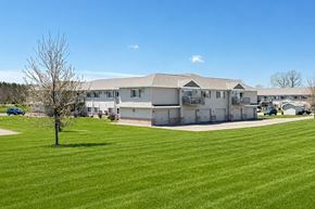 Marshfield apartment for rent - A large building with a green lawn in front of it.