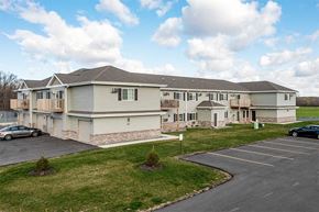 Marshfield apartment for rent - A large building with a parking lot in front.