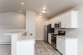 Marshfield apartment for rent - A kitchen with white cabinets and a black refrigerator.