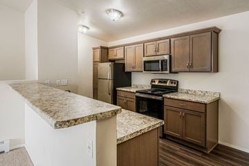 Plover apartment for rent - A kitchen with brown cabinets and granite countertops.