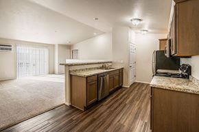 Plover apartment for rent - A kitchen with wooden cabinets and a granite countertop.
