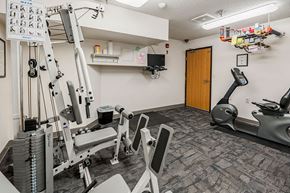 St Cloud apartment for rent - A gym with a variety of equipment including a treadmill, weights, and a bench press.