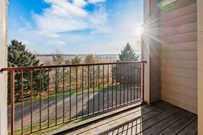 St Cloud apartment for rent - A balcony with a metal railing overlooking a road and trees.