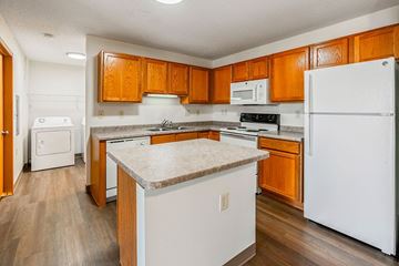 St Cloud apartment for rent - A kitchen with wooden cabinets and white appliances.