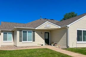 Stewartville apartment for rent - a tan house with a sidewalk in front of it