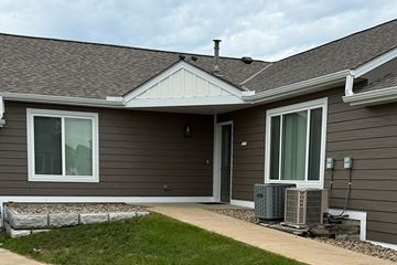 Stewartville apartment for rent - A house with a grey siding and a white window.