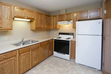 Stewartville apartment for rent - a kitchen with white appliances and wooden cabinets