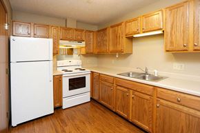 Stewartville apartment for rent - a kitchen with white appliances and wooden cabinets