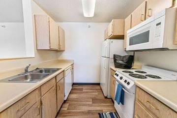 Newton apartment for rent - A kitchen with wooden cabinets and a white stove top oven.