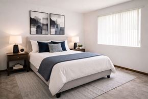 Carlinville apartment for rent - A bedroom with a large bed and two lamps on side tables.