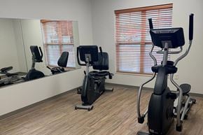 Beaver Dam apartment for rent - A gym room with a mirror, treadmill, and stationary bike.
