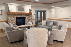 Beaver Dam apartment for rent - A living room with a stone fireplace and grey couches.