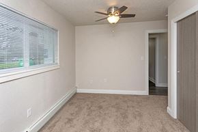 Rochester apartment for rent - an empty bedroom with a ceiling fan and a window