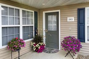 Grand Forks townhouse for rent - a front porch of a house with flowers and a gray door