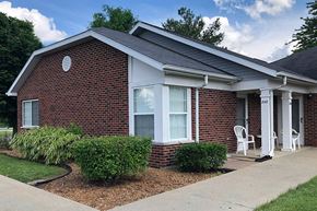 Carlinville apartment for rent - a small brick house with a porch and a sidewalk