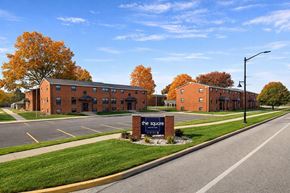 South Bend apartment for rent - The Square is a red brick building with a parking lot in front.