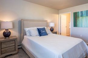 Fox Lake apartment for rent - a bedroom with a white bed and two lamps
