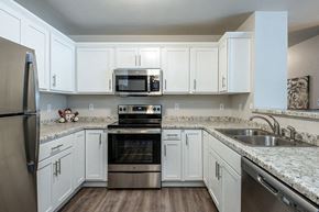 Reedsburg apartment for rent - a kitchen with stainless steel appliances and white cabinets