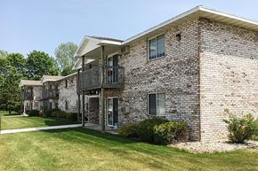 Sturgeon Bay apartment for rent - a brick building with a balcony and a lawn