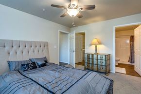 Neenah apartment for rent - A bedroom with a large bed and a ceiling fan.