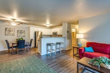 Neenah apartment for rent - A modern living room with a red couch and a dining table set up.