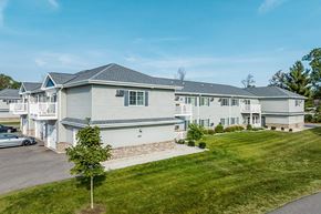 Wisconsin Rapids apartment for rent - A large grey house with a car parked in front.