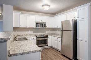 Plover apartment for rent - A kitchen with white cabinets and a granite countertop.
