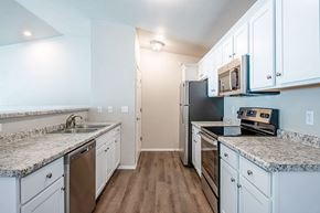 Plover apartment for rent - A kitchen with white cabinets and granite countertops.