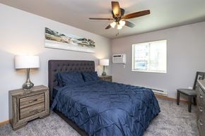 Onalaska apartment for rent - A bedroom with a bed, nightstand, and a ceiling fan.