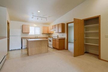 Neenah apartment for rent - an empty kitchen with a refrigerator and a sink