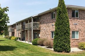 Sturgeon Bay apartment for rent - a brick apartment building with balconies and a tree