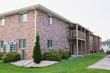 Sturgeon Bay apartment for rent - a brick apartment building with a balcony and grass