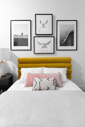 Ashburn apartment for rent - 1 bedroom model at Flats with photo frames above a yellow headboard