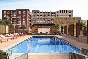 Rockville apartment for rent - A pool surrounded by chairs and buildings in the background.