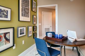 Rockville apartment for rent - a dining room with a table with a laptop on it and a wall with pictures