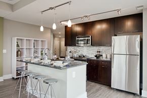 Rockville apartment for rent - a kitchen with a island with bar stools and a refrigerator