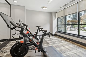 An exercise room with two bikes and a treadmill at the enclave at woodbridge apartments in sugar