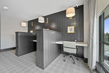 A room with a desk and chair in front of a window