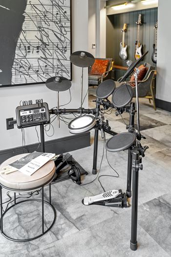 A drum set sits in front of a wall with a black and white map