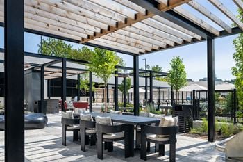 A patio with a table and chairs under a pergola
