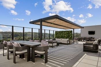A patio with a table and chairs under a roof